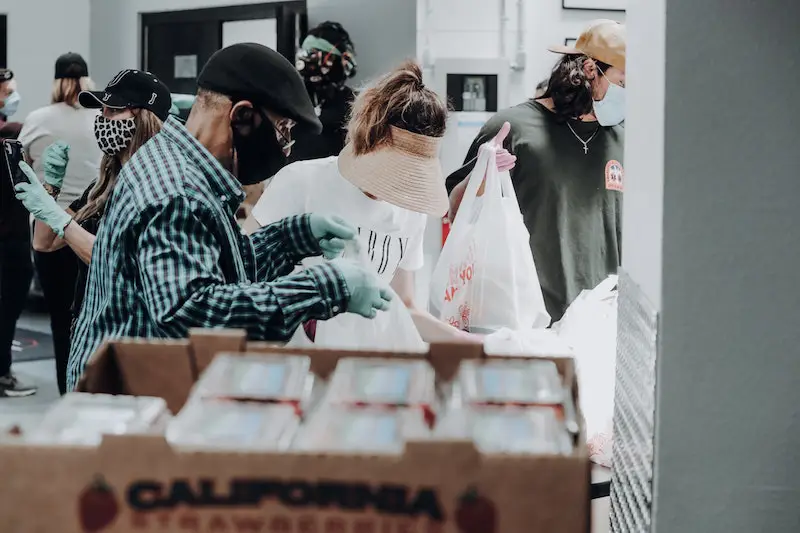 Volunteers help out during the coronavirus pandemic, wearing masks and distributing food. 