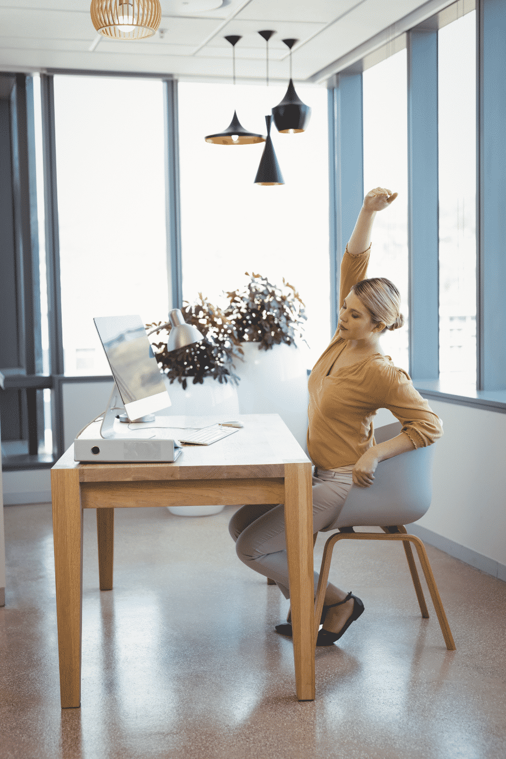 A woman stretches while working from home