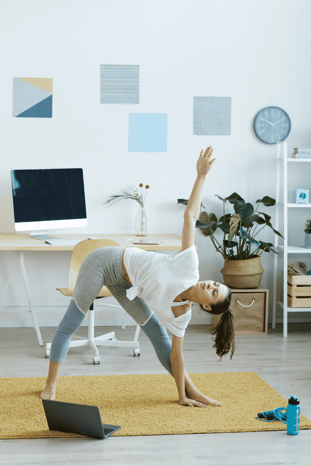 A woman does yoga in her home office