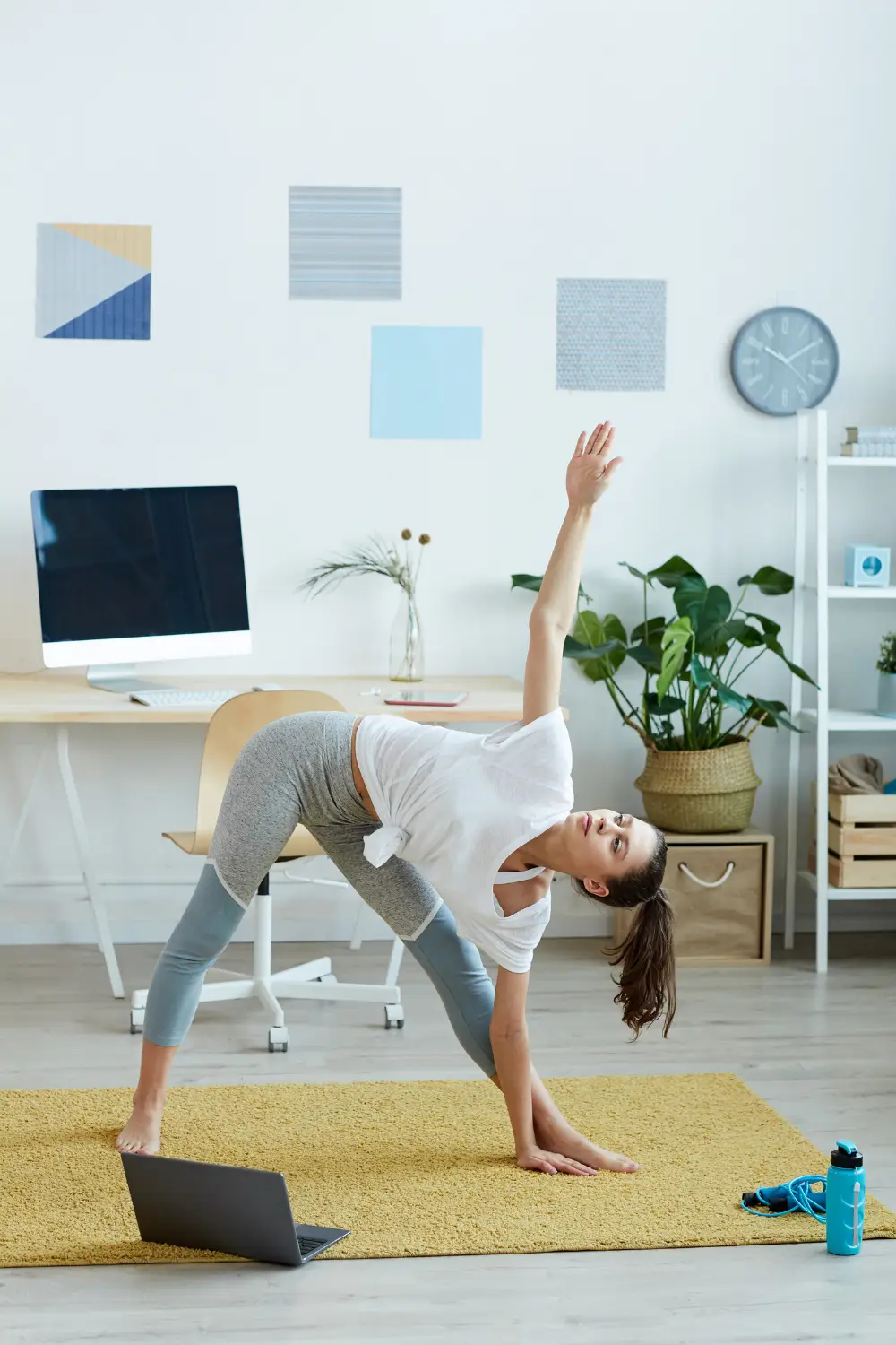A woman does yoga in her home office