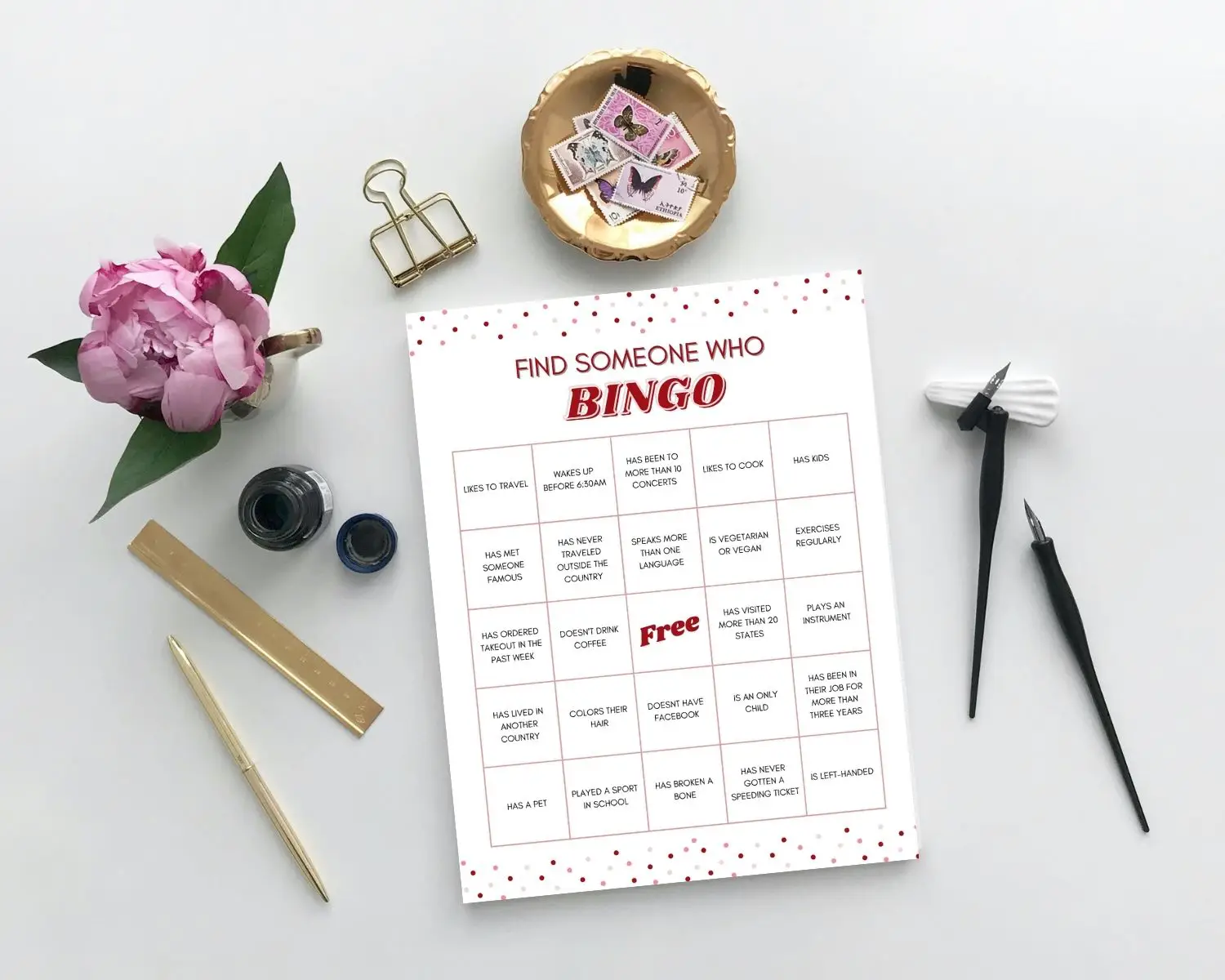Icebreaker Bingo sits on a desk next to some flowers and clips