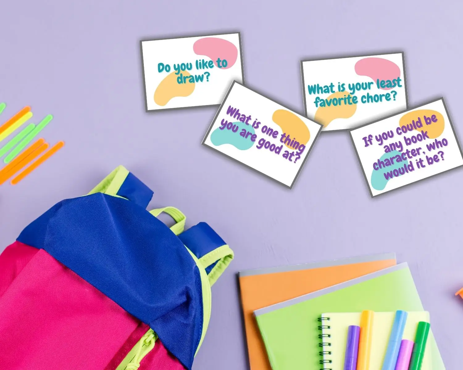 Kids conversation starters lay near a colorful backpack and notebooks