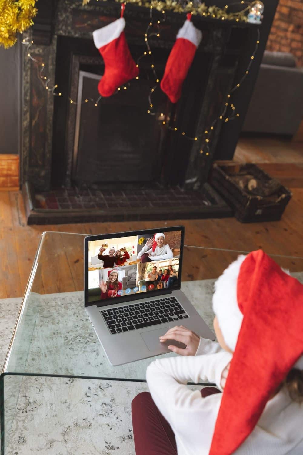 A woman sits on a Zoom call wearing a Santa Hat